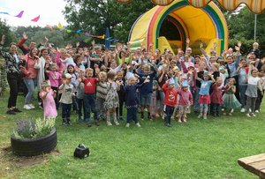 Eine Gruppe von Kindern und Erzieher*innen steht draußen.